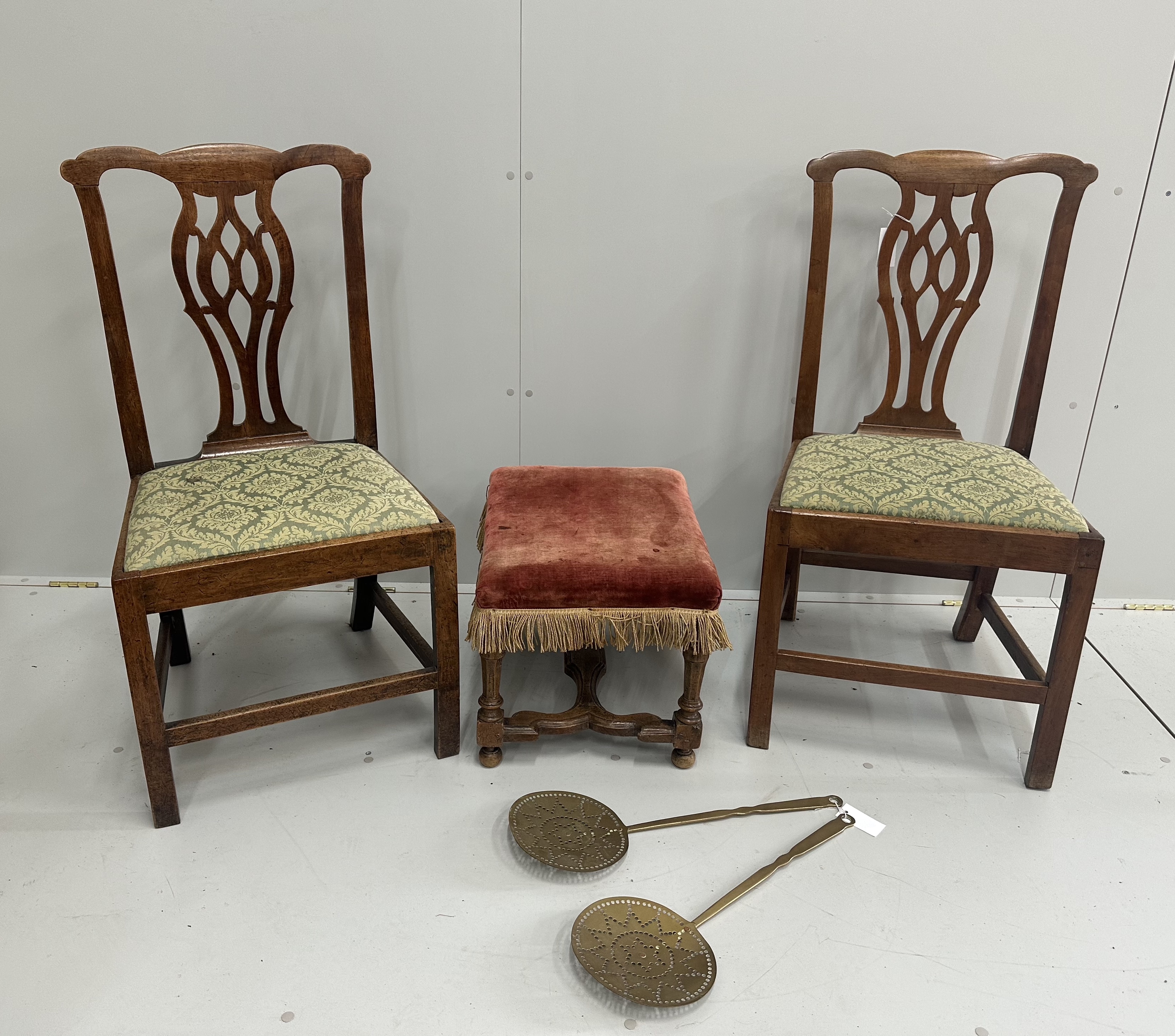 A pair of Chippendale style walnut dining chairs with drop in seats, an 18th century style walnut footstool and a pair of Victorian brass chestnut roasters